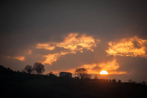 太阳落在山顶的农场后面 — 图库照片