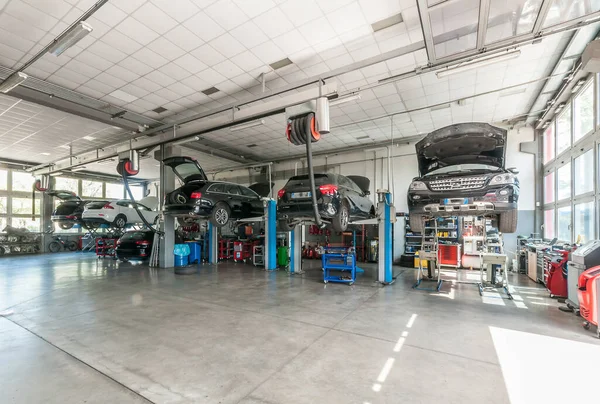 interior of mechanical workshop with cars on lifts