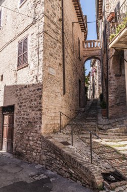 Umbria İtalya 'da bir ortaçağ kasabasının tarihi merkezinde dekoratif çiçeklerle dolu bir sokak.
