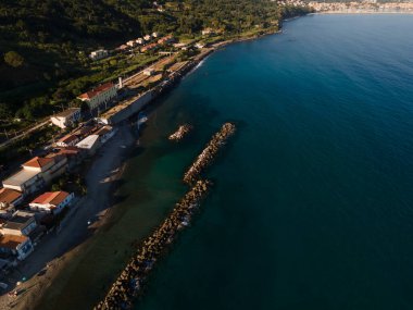 Uçurumun ve şeffaf mavi suyun havadan çekilmiş fotoğrafı.