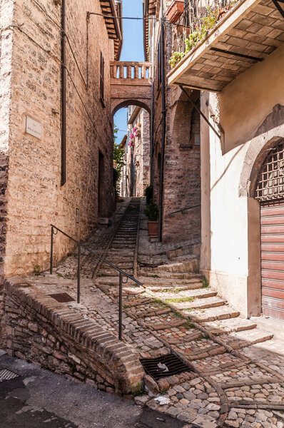 Alley with decorative flowers in the historic center of a medieval town in Umbria Italy