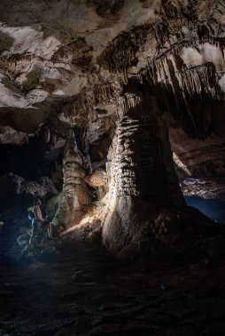 cavers inspect the cave with a light bulb looking for stalactites and stalagmites