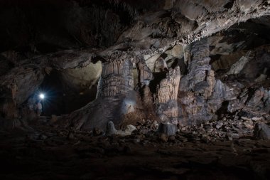 cavers inspect the cave with a light bulb looking for stalactites and stalagmites