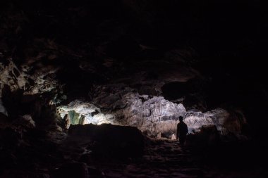 cavers inspect the cave with a light bulb looking for stalactites and stalagmites