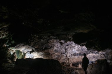 cavers inspect the cave with a light bulb looking for stalactites and stalagmites