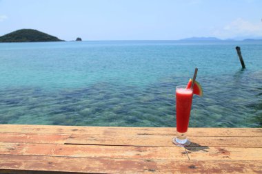 Karpuz suyuyla rahatla. Plaj adasında, dağ manzaralı bir yerde.