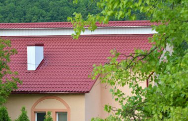 Çatısı metal kiremitlerle kaplı olan ev.