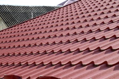 The house, the roof of which is covered with metal tiles clipart