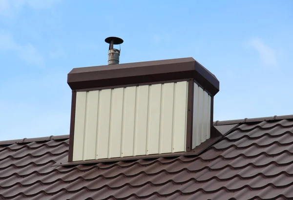 金属製のタイルや金属製のプロフィールで覆われた家の屋根の上に煙突 — ストック写真
