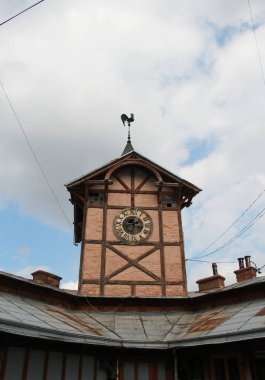 Dikeninde horoz olan eski saat kulesi.