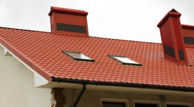 Çatısı metal kiremitlerle kaplı olan ev.