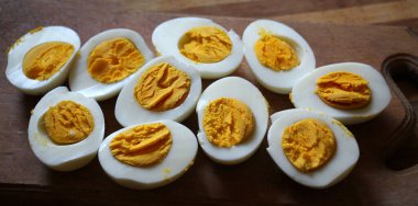 Haşlanmış tavuk yumurtaları mutfak tahtasında ikiye bölünmüş.