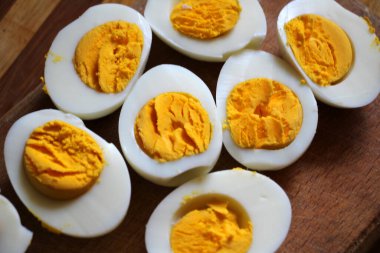 Haşlanmış tavuk yumurtaları mutfak tahtasında ikiye bölünmüş.