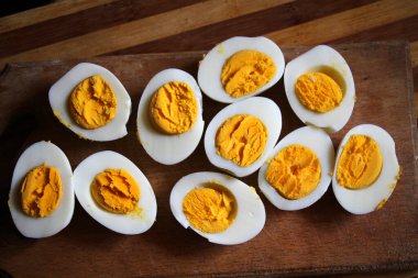 Haşlanmış tavuk yumurtaları mutfak tahtasında ikiye bölünmüş.