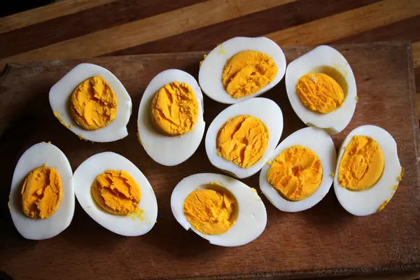 Haşlanmış tavuk yumurtaları mutfak tahtasında ikiye bölünmüş.