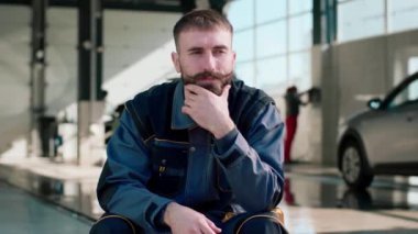 Araba yıkama şirketinin çalışanlarından biri düşünüyor. 4K