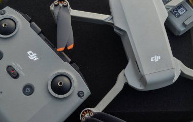 MALANG, INDONEZYA - 6 Kasım 2022, Gri DJI Mini 2 insansız hava aracı ve çantanın üstündeki ve doğadaki uzaktan kumanda