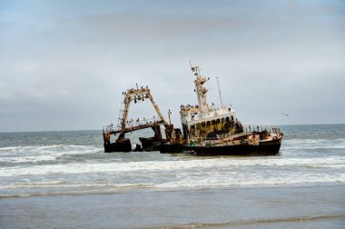 The thrown old ship has sat down on a bank - Namib desert with Atlantic ocean meets near Skeleton coast - Namibia, South Africa