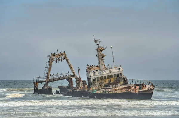The thrown old ship has sat down on a bank - Namib desert with Atlantic ocean meets near Skeleton coast - Namibia, South Africa