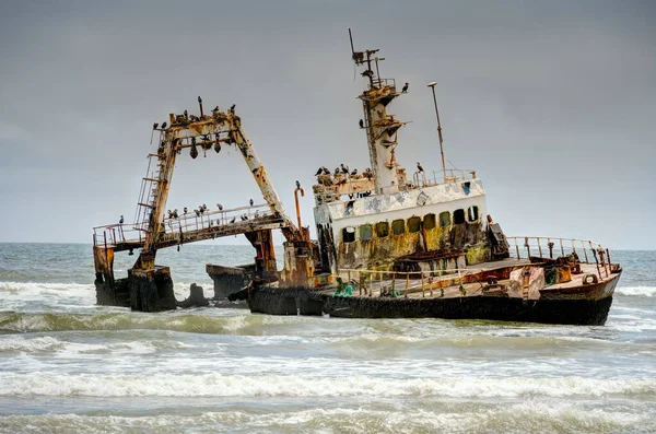 The thrown old ship has sat down on a bank - Namib desert with Atlantic ocean meets near Skeleton coast - Namibia, South Africa