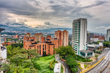 Medellin, Kolombiya - Mayıs 2019: Bulutlu havada dağların arasında şehrin havadan görünüşü