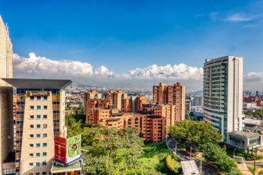 Medellin, Kolombiya - Mayıs 2019: Bulutlu havada dağların arasında şehrin havadan görünüşü