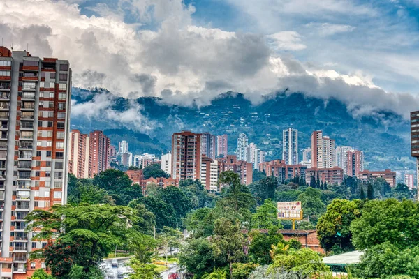 Medellin, Kolombiya - Mayıs 2019: Bulutlu havada dağların arasında şehrin havadan görünüşü