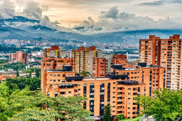 Medellin, Kolombiya - Mayıs 2019: Bulutlu havada dağların arasında şehrin havadan görünüşü