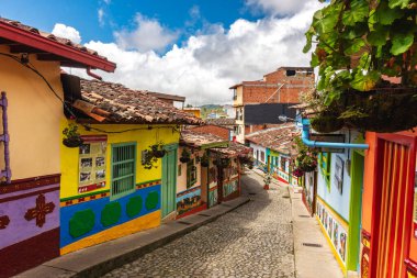 Guatape, Kolombiya - Nisan 2019: Bulutlu havada renkli evler, HDR resmi