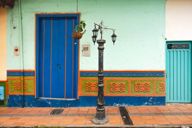 Guatape, Kolombiya - Nisan 2019: Bulutlu havada renkli evler, HDR resmi