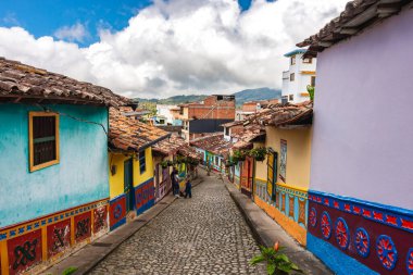 Guatape, Kolombiya - Nisan 2019: Bulutlu havada renkli evler, HDR resmi