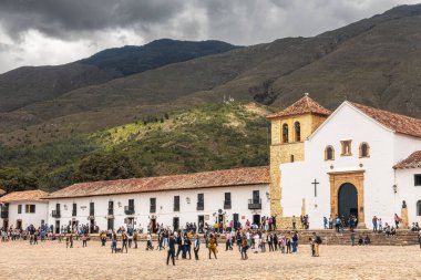 Villa de Leyva, Kolombiya - 20 Nisan 2019: Bulutlu bir günde tarihi kent meydanında kalan turistler. 