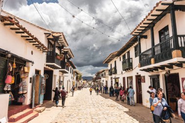 Villa de Leyva, Kolombiya - 20 Nisan 2019: Bulutlu bir günde tarihi kent meydanında kalan turistler. 