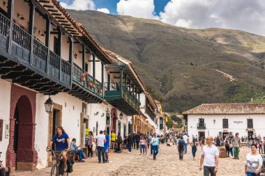 Villa de Leyva, Kolombiya - 20 Nisan 2019: Bulutlu bir günde tarihi kent meydanında kalan turistler. 