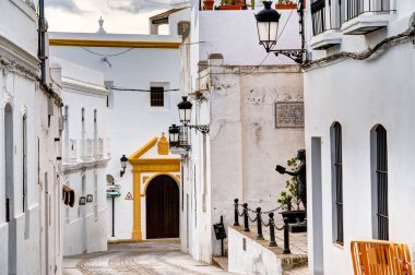 Vejer de la Frontera, İspanya - 1 Ağustos 2023: Bulutlu havada antik binalarla tarihi şehir merkezinin güzel manzarası, HDR Image