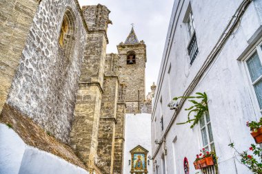 Vejer de la Frontera, İspanya - 1 Ağustos 2023: Bulutlu havada antik binalarla tarihi şehir merkezinin güzel manzarası, HDR Image