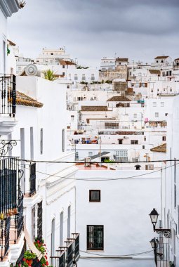 Vejer de la Frontera, İspanya - 1 Ağustos 2023: Bulutlu havada antik binalarla tarihi şehir merkezinin güzel manzarası, HDR Image