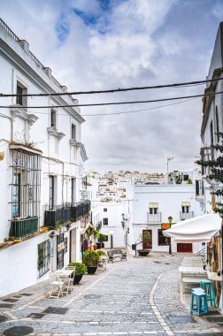 Vejer de la Frontera, İspanya - 1 Ağustos 2023: Bulutlu havada antik binalarla tarihi şehir merkezinin güzel manzarası, HDR Image