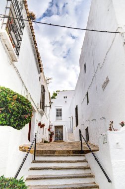 Vejer de la Frontera, İspanya - 1 Ağustos 2023: Bulutlu havada antik binalarla tarihi şehir merkezinin güzel manzarası, HDR Image