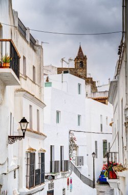 Vejer de la Frontera, İspanya - 1 Ağustos 2023: Bulutlu havada antik binalarla tarihi şehir merkezinin güzel manzarası, HDR Image