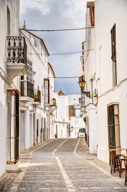 Vejer de la Frontera, İspanya - 1 Ağustos 2023: Bulutlu havada antik binalarla tarihi şehir merkezinin güzel manzarası, HDR Image