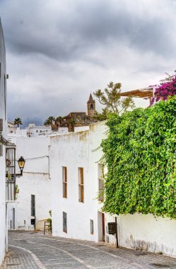 Vejer de la Frontera, İspanya - 1 Ağustos 2023: Bulutlu havada antik binalarla tarihi şehir merkezinin güzel manzarası, HDR Image