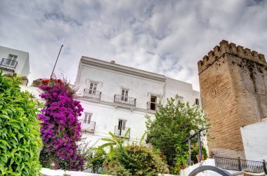 Vejer de la Frontera, İspanya - 1 Ağustos 2023: Bulutlu havada antik binalarla tarihi şehir merkezinin güzel manzarası, HDR Image