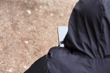 Yukarıdan akıllı telefon kullanan tanınmayan bir adamın fotoğrafı