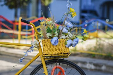 Mavi ve sarı çiçeklerle süslenmiş klasik sarı bir bisiklet parçası. Ukrayna 'nın vatanseverlik güdüleri. Seçici odaklanma. Düşük Dof.