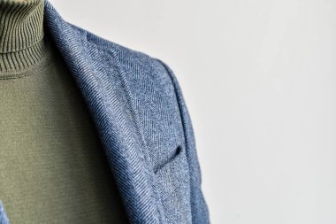 Erkeklerin günlük kıyafetlerinin, mavi yün ceketlerinin ve yeşil kazaklarının detaylarını kapat. Seçici odak.