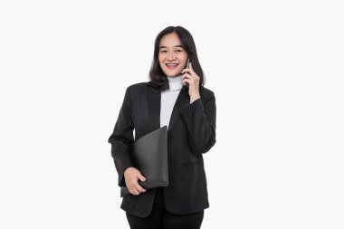Mutlu Asyalı iş kadını beyaz arka planda bir iş ortağıyla telefon görüşmesi yapıyor.