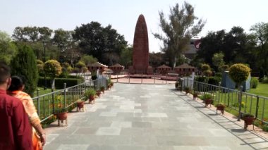 AMRITSAR, INDIA - 19 Mart 2019: ziyaretçiler Amritsar, Hindistan 'daki Jallianwala Bagh Anıtı' na doğru yürür