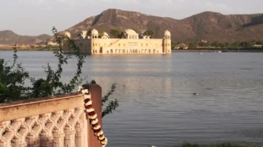 Jaipur, Hindistan 'ın arka planında Jal Mahal sarayının asılı olduğu bir çelenk klibi.