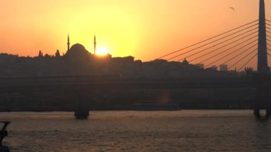 İstanbul 'da siluetli bir caminin arkasında gün batımı, hindi